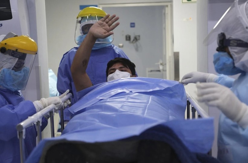 Một bệnh nhân được chuyển ra khỏi khu điều trị đặc biệt ở Lima, Peru (Ảnh: AP)