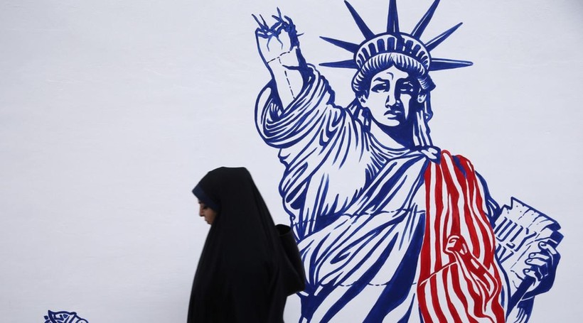 Một phụ nữ đi ngang bức biếm họa trên tường tòa đại sứ quán cũ của Mỹ ở Tehran, Iran (Ảnh: Reuters)