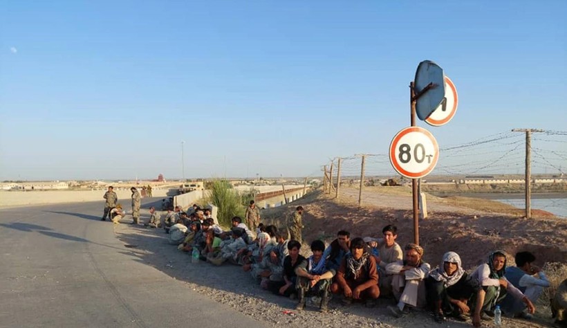 Các binh sĩ Afghanistan ngồi bên một cây cầu gần biên giới với Tajiskistan hồi tháng 6/2021 (Ảnh: AP)