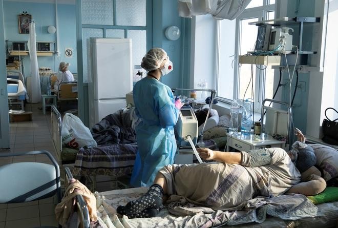 Nhân viên y tế điều trị cho bệnh nhân Covid-19 ở Ukraine hôm 26/10 (Ảnh: Reuters).