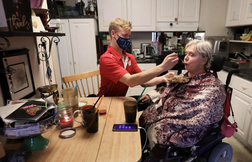 Nhân viên chăm sóc Andrew Wolfram giúp bà Karen Foxgiver ăn trưa bên trong căn hộ của bà (Ảnh: Madison)