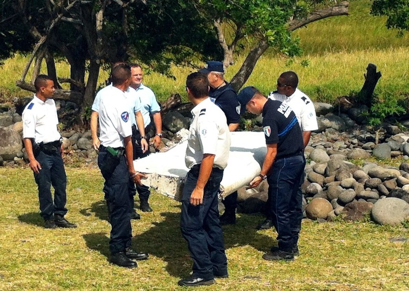 Cảnh sát mang mảnh vỡ từ chiếc máy bay được tìm thấy trên đảo Reunion, ngày 29/7/2015 (Ảnh: AFP)