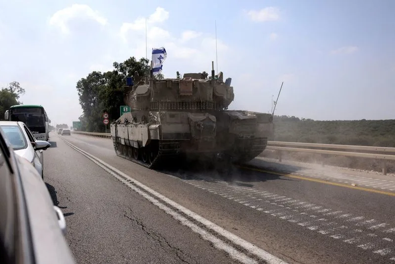 Một chiếc xe tăng của Israel di chuyển trên tuyến đường gần Sderot (Ảnh: Reuters)
