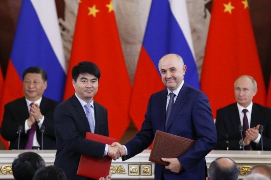 Guo Ping, phó chủ tịch Huawei bắt tay chủ tịch MTS Alexei Kornya sau khi ký kết thỏa thuận hợp tác, với sự chứng kiến của Tổng thống Nga Vladimir Putin và Chủ tịch Trung Quốc Tập Cận Bình. (Ảnh: AP)
