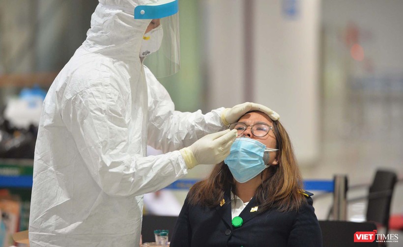 Nhân viên y tế lấy dịch mũi xét nghiệm COVID-19 cho cán bộ làm việc tại sân bay Nội Bài. Ảnh: Hoàng Anh