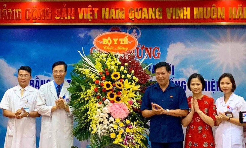 Thứ trưởng Bộ Y tế Đỗ Xuân Tuyên (áo xanh) chúc mừng em bé đầu tiên ra đời bằng kỹ thuật thụ tinh trong ống nghiệm. (Ảnh: Thảo Nguyên)