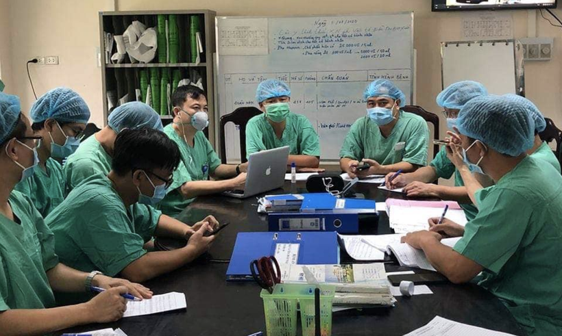 Các bác sĩ của Bệnh viện Đại học Y Hà Nội cùng Bệnh viện Bệnh Nhiệt đới Trung ương hội chẩn ca bệnh nặng tại Bệnh viện Trung ương Huế (Ảnh: Vũ Mạnh Cường) 