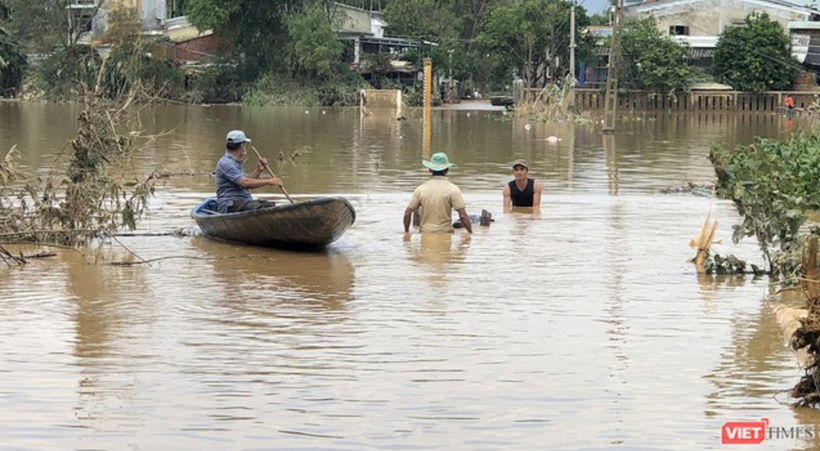 Người dân di chuyển bằng thuyền khi nước lũ dâng cao (Ảnh: Hồ Xuân Mai) 