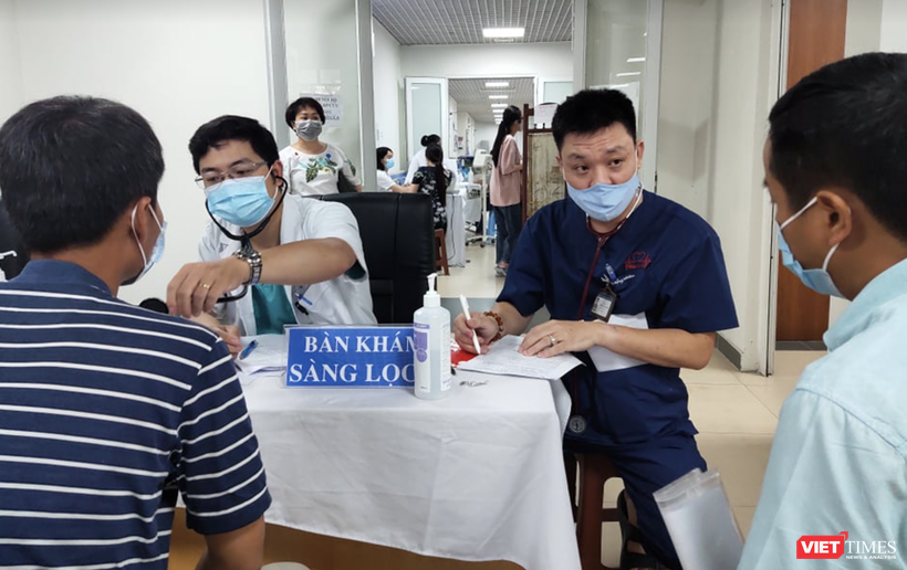 Bác sĩ khám sàng lọc cho người dân trước khi tiêm vaccine phòng COVID-19 (Ảnh - Minh Thuý) 