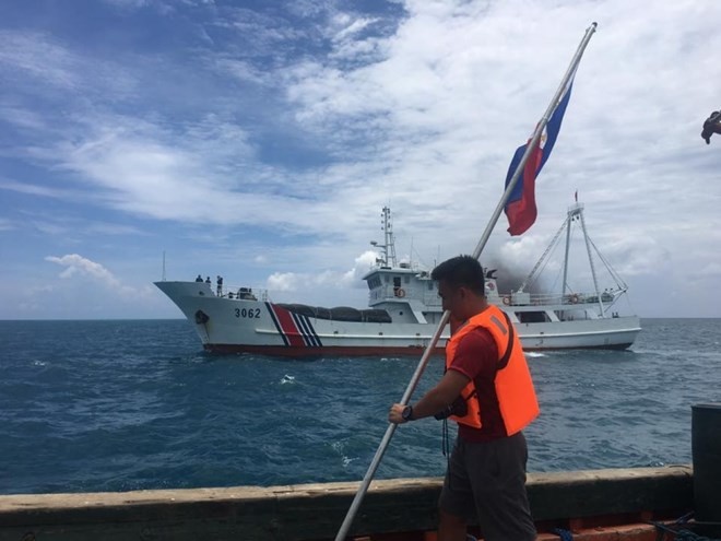 Một thành viên của nhóm Kalayaan Atin Ito đang thực hiện cắm quốc kỳ Philippines trên bãi cạn Scarborough nhưng bị Trung Quốc cản trở.