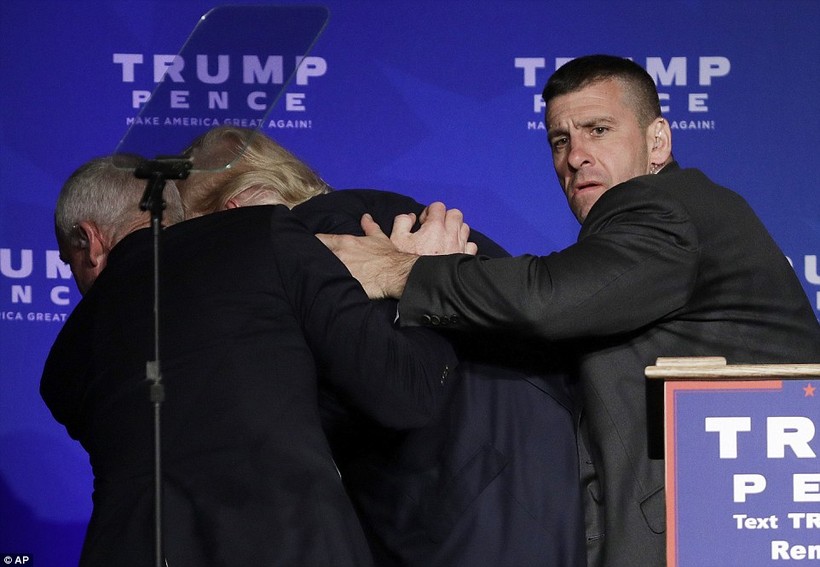 Donald Trump bị một phen hú hồn, phải chạy vào sau sân khấu dưới sự yểm trợ của nhân viên an ninh.