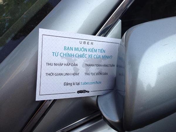 Một mẩu quảng cáo của Uber gắn trên kiếng xe chiếu hậu của chủ một xe hơi ở TPHCM