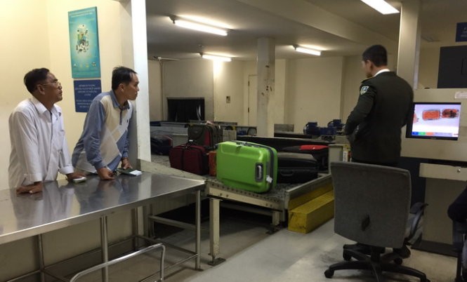 Hành khách đi nước ngoài chờ kiểm tra hành lý ký gửi tại phòng soi của hải quan sân bay quốc tế Tân Sơn Nhất chiều 7-4