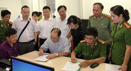 Đối tượng Yin Wen Sheng (áo tím) cùng hồ sơ, tài liệu được cơ quan chức năng Việt Nam bàn giao cho phía Trung Quốc.