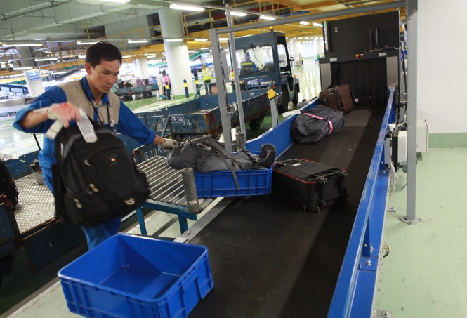 Hành lý ký gửi từ máy bay đến được đưa vào băng chuyền ra đảo hành lý tại cảng hàng không Nội Bài