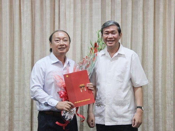 Ông Đinh Thế Huynh trao quyết định và tặng hoa chúc mừng ông Võ Văn Phuông. 