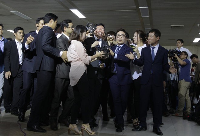 Ông Shin Dong Bin (giữa) trong vòng vây phóng viên sau khi hoàn toàn nắm quyền kiểm soát tập đoàn Lotte. Ảnh: AFP