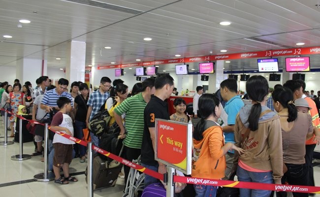 Hành khách xếp hàng dài chờ đợi làm thủ tục tại sân bay Tân Sơn Nhất - Ảnh: Anh Quân