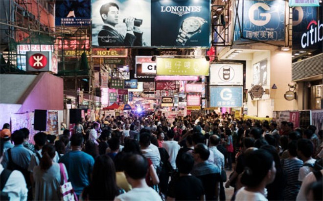 Du khách trên đường phố ở quận Mong Kok của Hồng Kông - Ảnh: Bloomberg