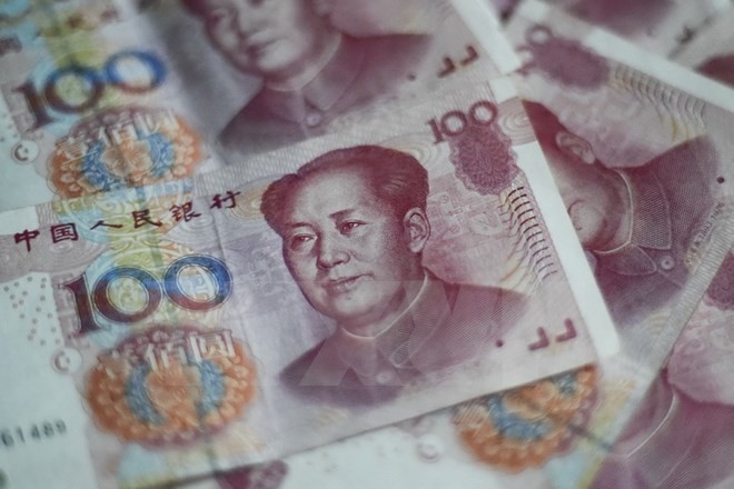 Đồng tiền giấy mệnh giá 100 NDT (15.5 USD) tại Bắc Kinh ngày 25/8 vừa qua. (Ảnh: AFP/TTXVN)