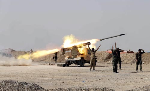Các tay súng Shiite phóng rốc két về phía mục tiêu của tổ chức Nhà nước Hồi giáo (IS) tự xưng ở TP Baiji - Iraq Ảnh: REUTERS