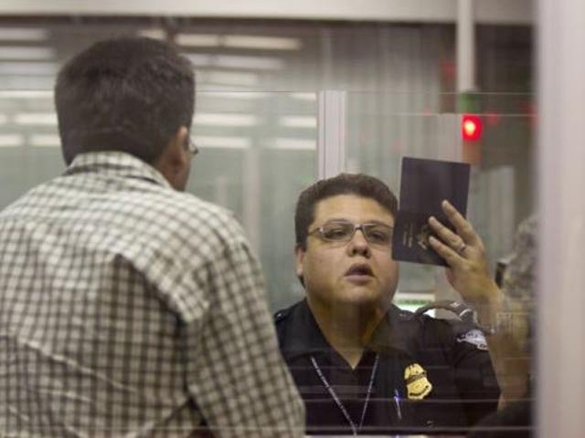 Nhân viên hải quan Mỹ kiểm tra hộ chiếu của hành khách. Ảnh: AP