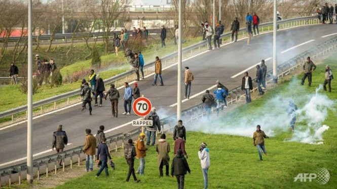 Cảnh sát Pháp dùng hơi cay giải tán đám đông những người di cư cố vào đường hầm để qua Anh - Ảnh: AFP