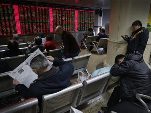 Các nhà đầu tư theo dõi giá chứng khoán ở thủ đô Bắc Kinh – Trung Quốc hôm 5-1 Ảnh: AP