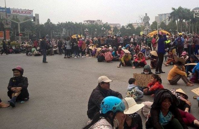 Người dân Sầm Sơn ngồi la liệt giữa ngã tư đại lộ Lê Lợi - Trần Phú (TP Thanh Hóa) để phản đối chính quyền giao đất cho FLC. Ảnh: Nguyễn Dương.