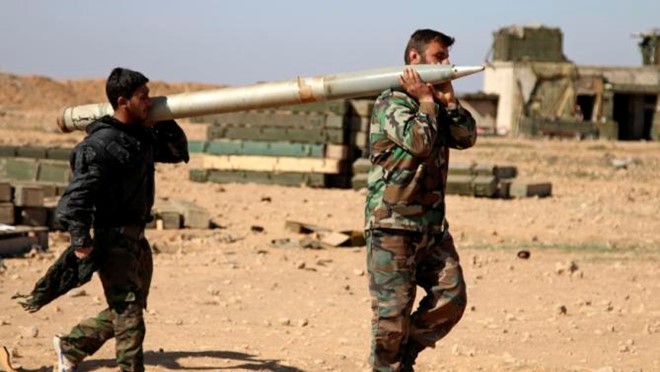 Binh sĩ chính phủ Syria vác rocket để bắn về phía lực lượng IS ở tỉnh Raqqa hôm 17/2. Ảnh: AP