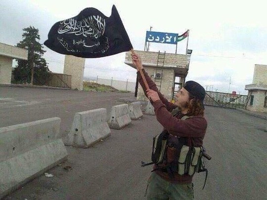 Một chiến binh IS giương cờ của tổ chức tại khu vực biên giới Jordan. Ảnh: Debka