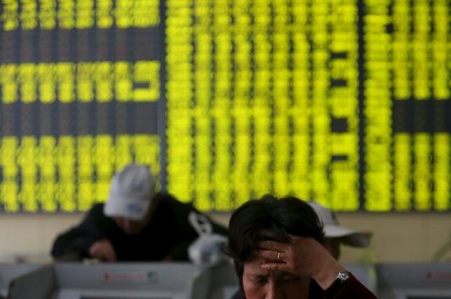 Các nhà đầu tư xem xét thông tin tại một sàn giao dịch chứng khóa ở tỉnh Giang Tô, Trung Quốc - Ảnh: Reuters