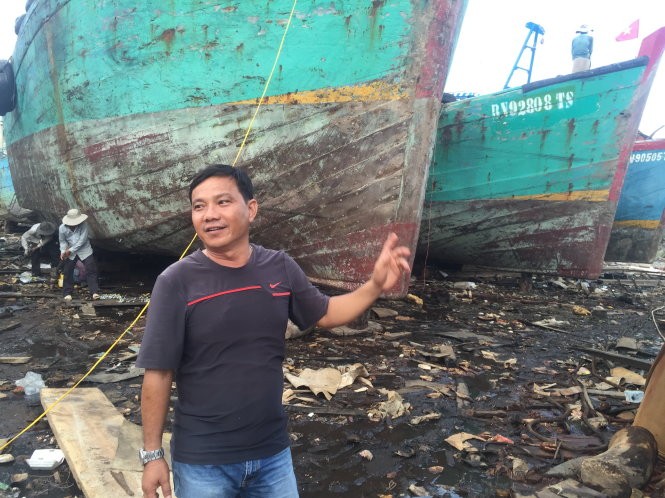 Ông Trà Văn Hoành bên tàu gỗ cỡ lớn đang bảo trì, sửa chữa định kỳ - Ảnh: MINH ĐỨC