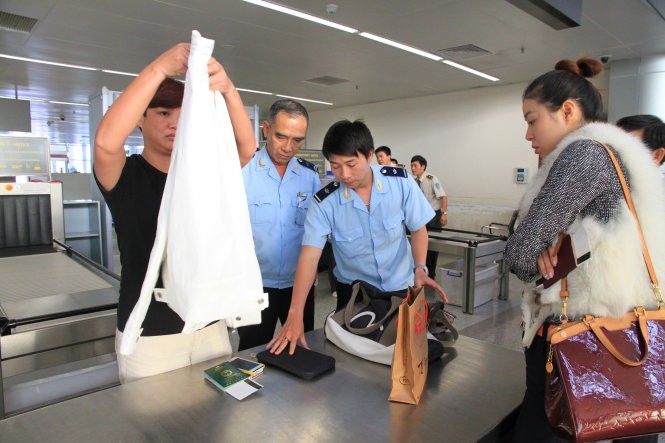 Nhân viên hải quan kiểm tra tư trang hành lý của hành khách tại sân bay quốc tế Đà Nẵng - Ảnh: Sa Sa