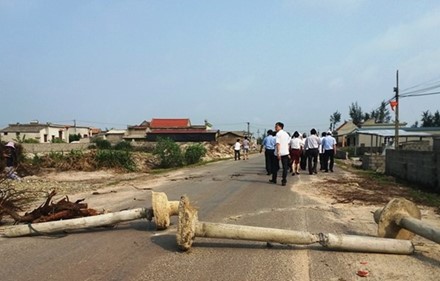 Người dân dùng cột điện và cây cối để ngăn chặn các phương tiện tại lễ khởi công ngày 24.4 của Tập đoàn FLC tại Quảng Bình. Ảnh: Lê Phi Long