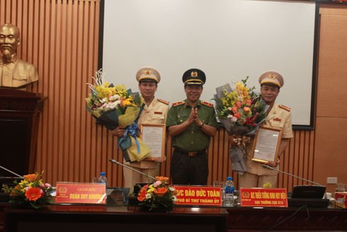 Giám đốc CATP Hà Nội trao quyết định và tặng hoa chúc mừng 02 tân Phó Giám đốc CATP. Ảnh: Công an Hà Nội