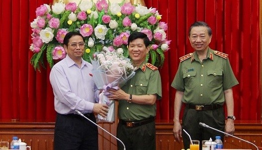 Trung tướng Nguyễn Văn Sơn nhận hoa chúc mừng từ Trưởng Ban Tổ chức Trung ương Phạm Minh Chính. (Nguồn: mps.gov.vn)