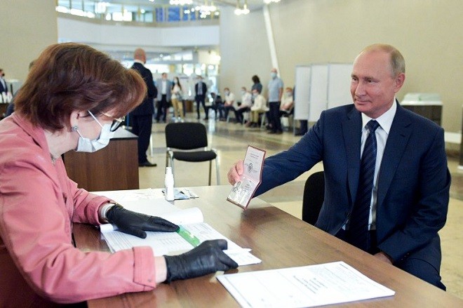Tổng thống Nga V.Putin trình hộ chiếu của mình tại trạm bỏ phiếu về sửa đổi Hiến pháp tại một trạm bầu cử ở Moscow ngày 01/07/2020 (Ảnh:TASS). 