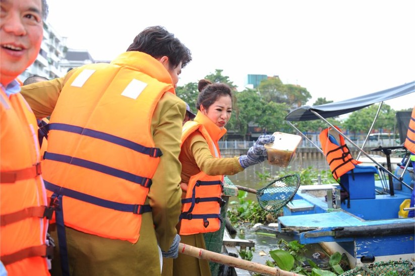 Thúy Nga tự tay vớt rác trên kênh Thị Nghè. Người đẹp diện chiếc áo dài Việt Hùng được làm bằng chất liệu thân thiện với môi trường