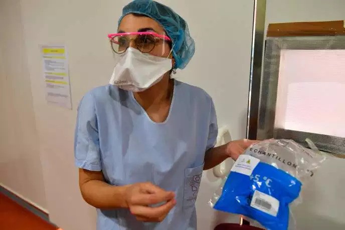 Một y tá của Bệnh viện Đại học Bordeaux mang mẫu được lấy từ bệnh nhân vào ngày 9/3. (Ảnh:AFP)