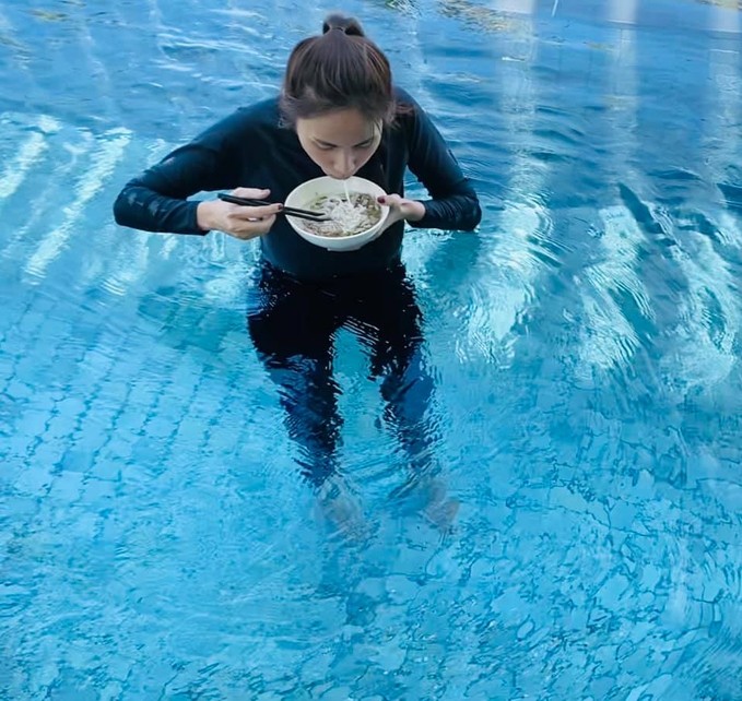 Thủy Tiên mặc đồ dài tay xuống bể bơi ăn sáng