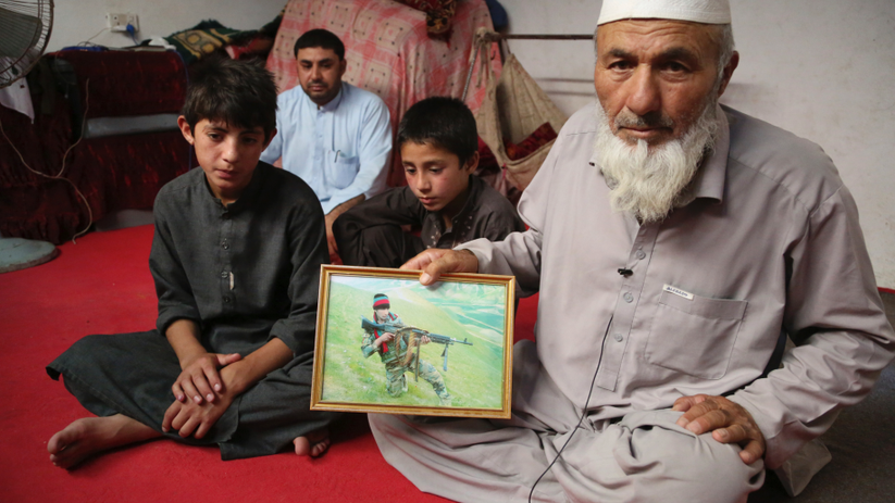Ông Noor Mohammad, người tháo chạy khỏi ngôi làng của mình ở Nangarhar hồi cuối tháng 4 vừa qua do IS truy quét, cầm trên tay bức ảnh người con trai thiệt mạng trong lúc chiến đấu (Ảnh: AP)